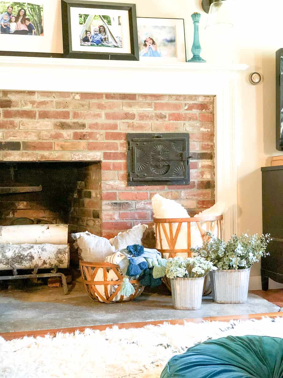 The galvanized buckets in front of the fireplace with eucalyptus in them.