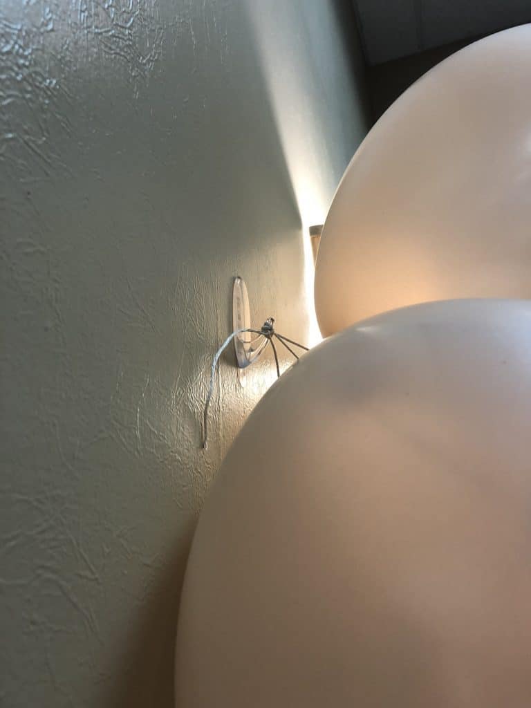 Attaching the balloons to the wall with a hook and string.