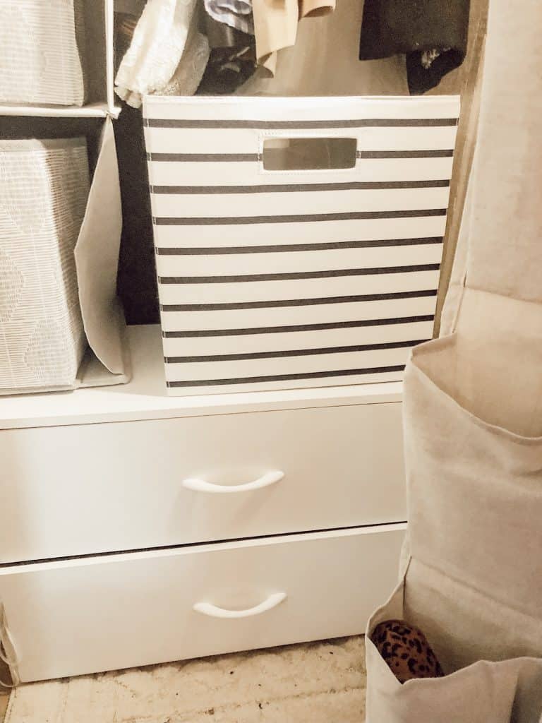 A black and white storage bin on top of the cabinet drawers.