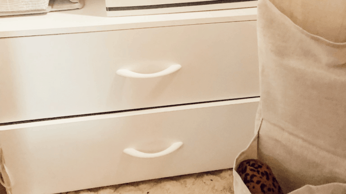 White cabinet drawers on the floor in the closet.