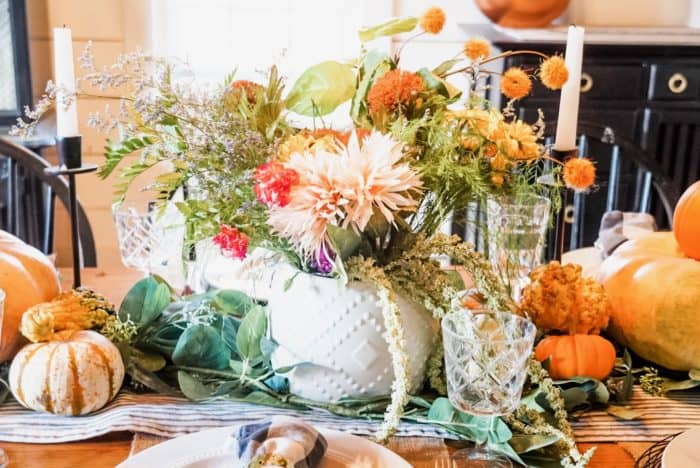 The floral centerpiece with pumpkins, and a striped table runner.