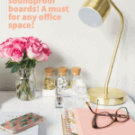 gold lamp on desk with glasses and pink flowers