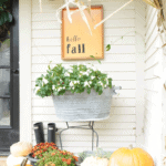 front porch decor with orange fall sign that says hello Fall