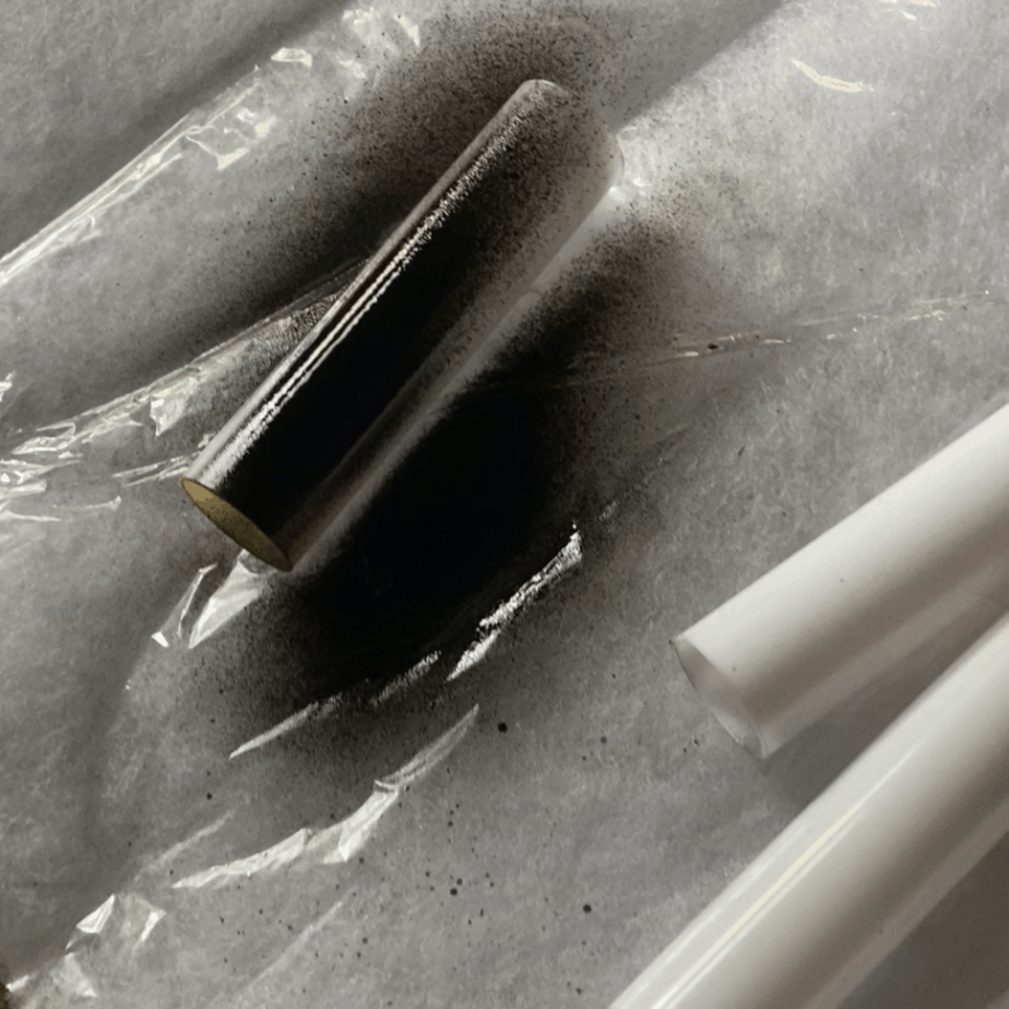 black spray paint on white plastic cylendars 