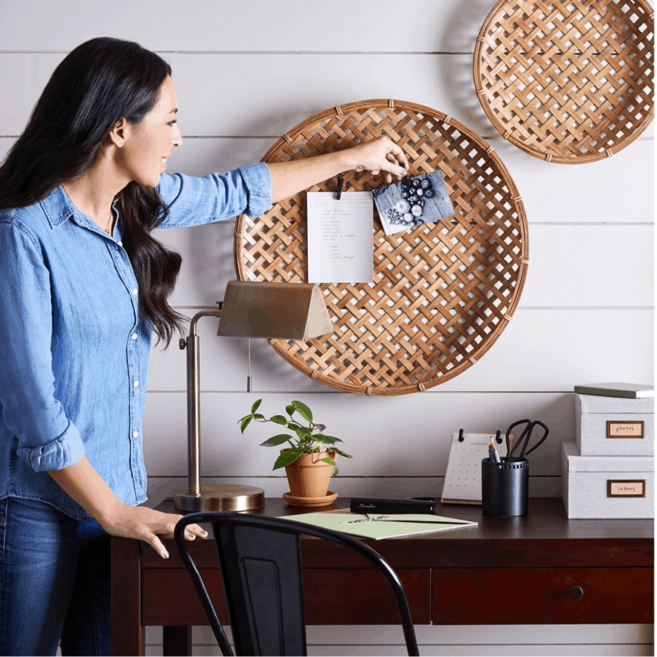 Joanna Gaines hanging up pictures on a wall basket as an organizer