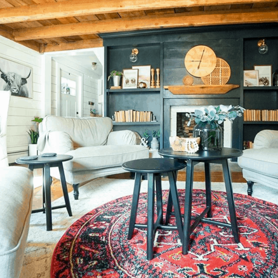 boho farmhouse style living room with black fireplace and builtins and basket wall and clock on mantel