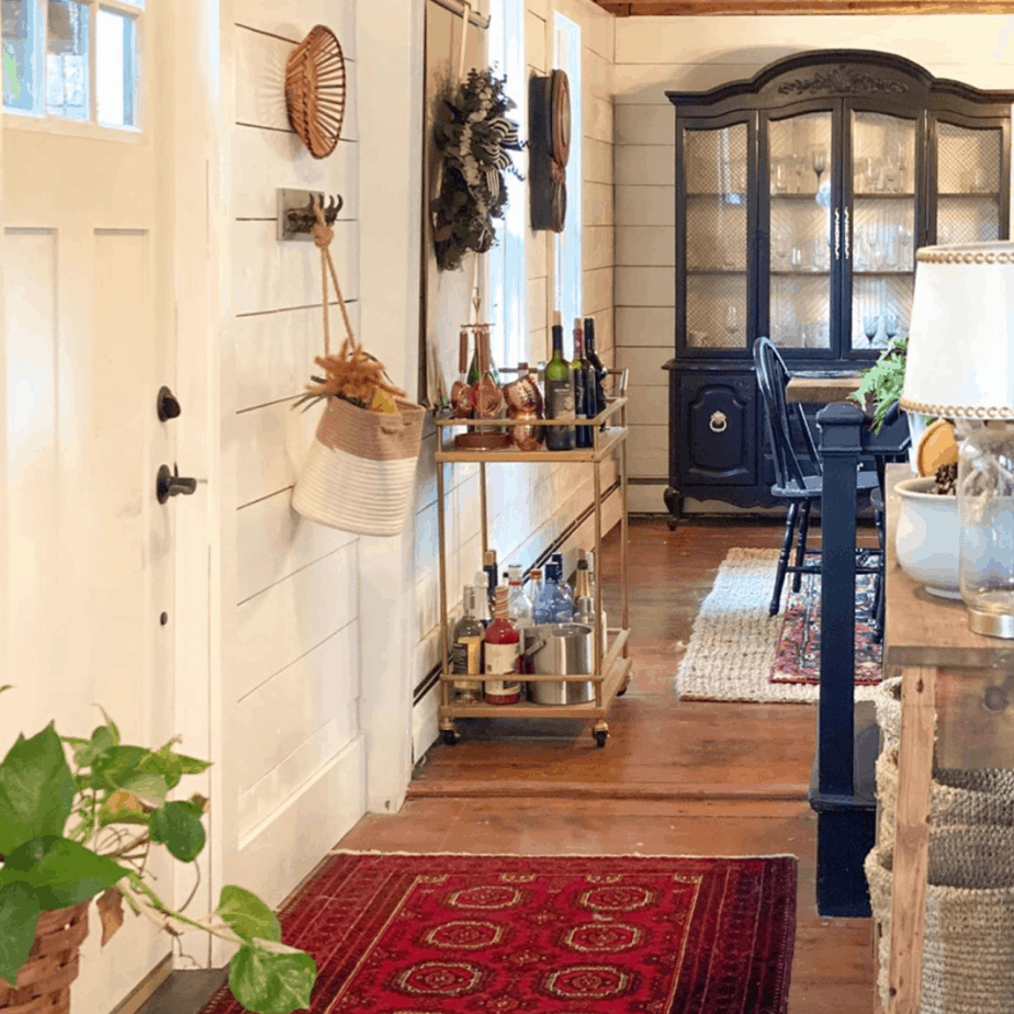 entryway with red rug and wooden entryway table