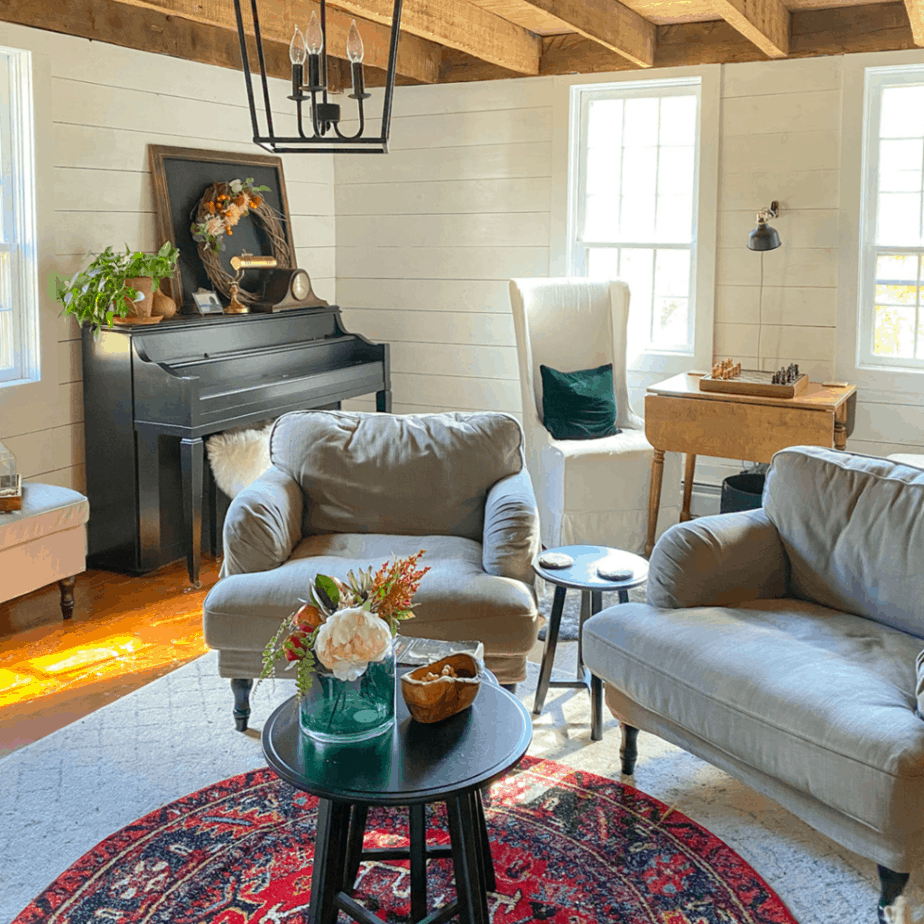 sitting room with two large gray chairs and red boho rug