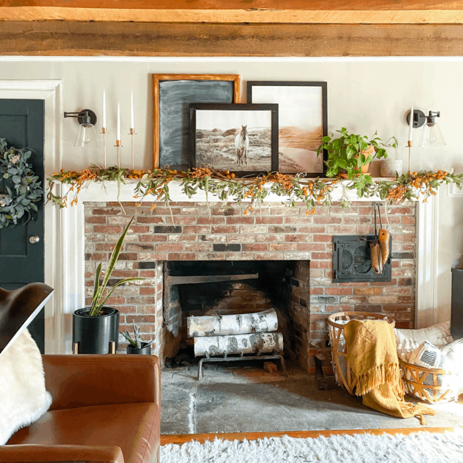 brick fireplace with horse picture on mantel and fall garland