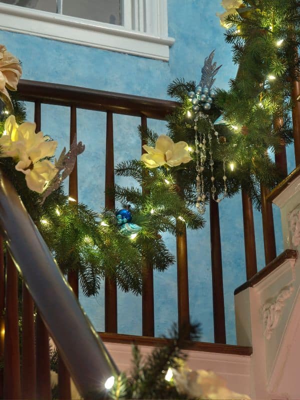 Staircase garland with yellow flowers and white lights.