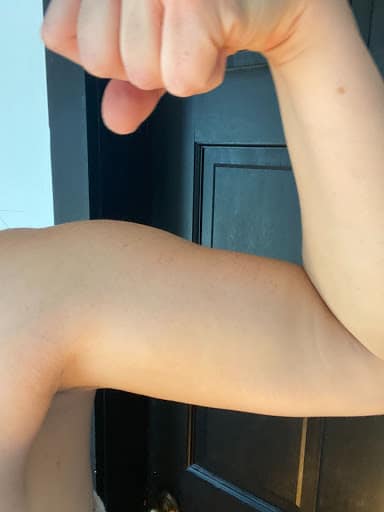 Woman flexing her arm showing her muscle.