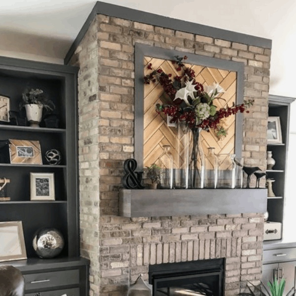brick fireplace with wooden frames wall art with florals and jar on the mantel