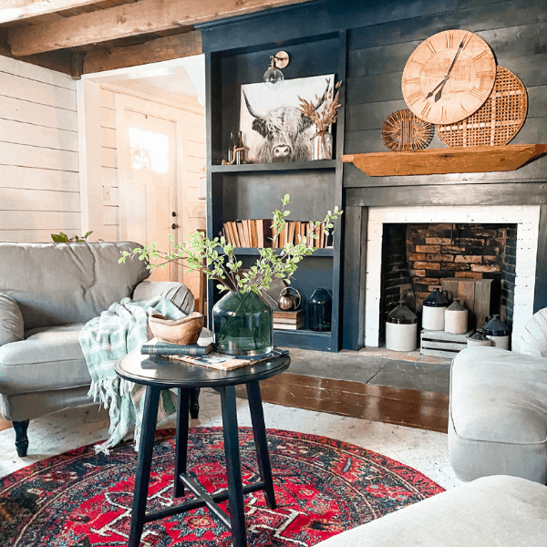 living room with dark fireplace wall and clock styled on mantel