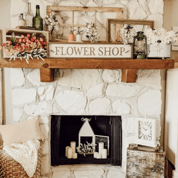 white fireplace with wooden mantel and flower shop sign.