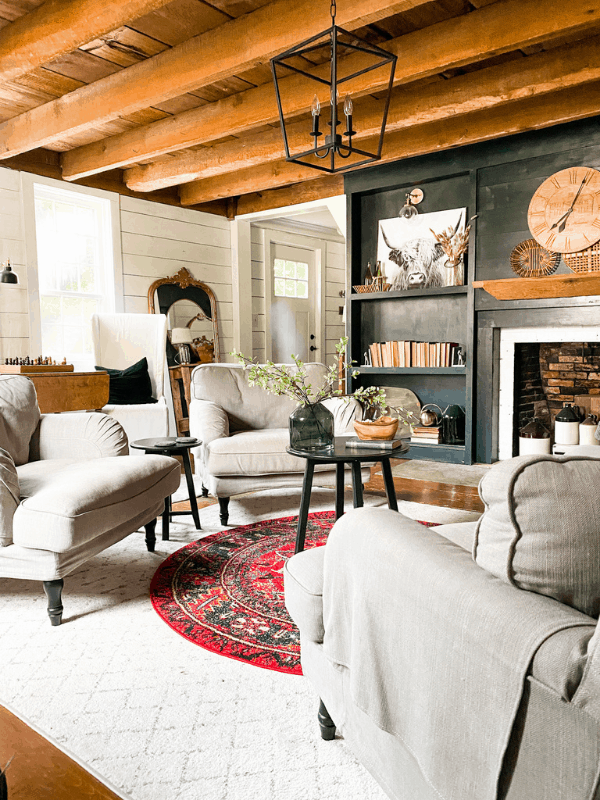 Boho farmhouse living room with dark fireplace surround and shiplap on walls.
