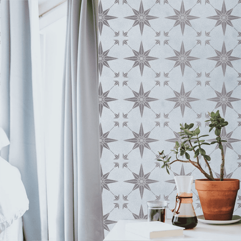 Homemade wallpaper with a DIY stencil on a white wall with gray stars and gray curtains.