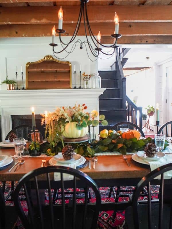 Dining table with runner and a pumpkin vase as the centerpiece.