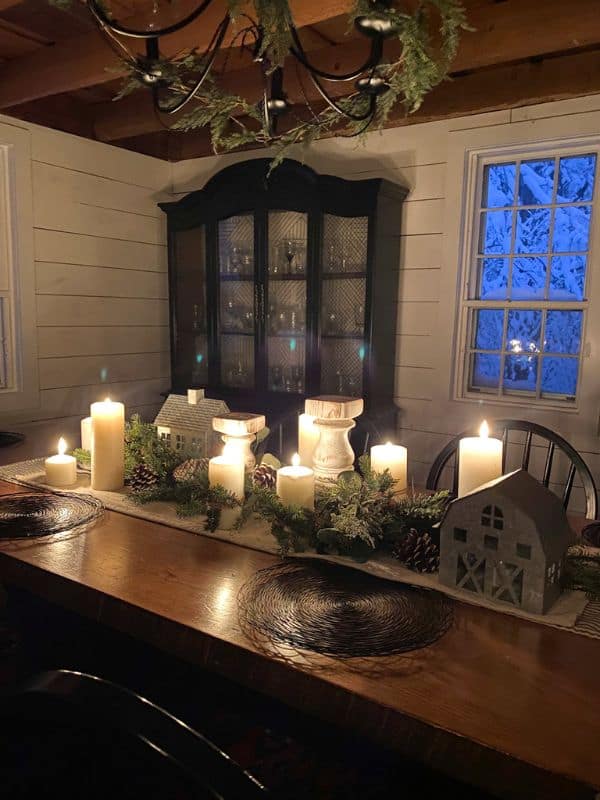 Christmas dining table centerpiece with candles and garland.