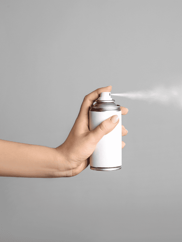 woman spraying white spray paint into the air