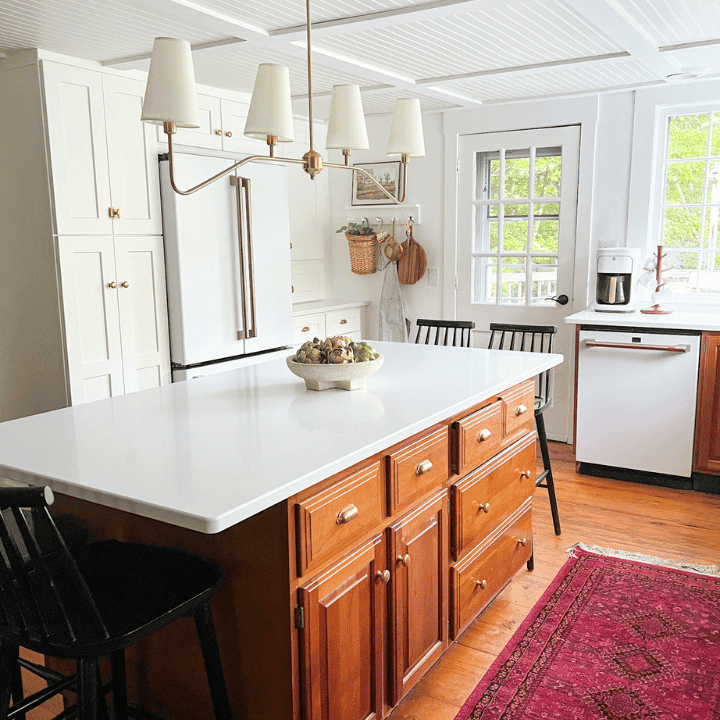 wooden island with white countertop and red runner in kitchen