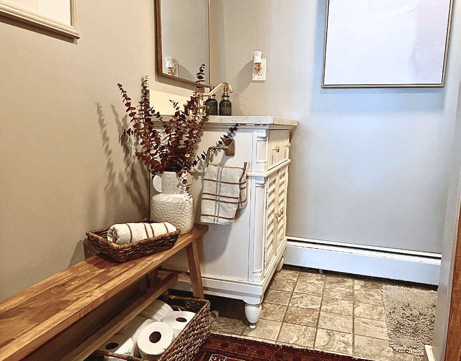 Bathroom nech and small vanity with a vase and dried stems.